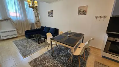 a living room with a table and a blue couch at Апартамент Amare, Гранд Манастира in Pamporovo