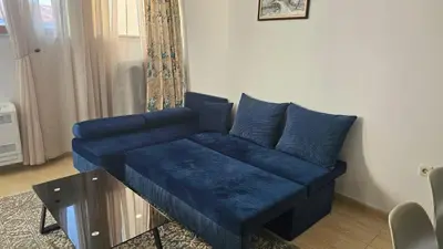 a blue couch sitting in a living room at Апартамент Amare, Гранд Манастира in Pamporovo
