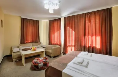 a large hotel room with two beds and a couch at HOTEL THE WHITE HOUSE Plovdiv in Plovdiv