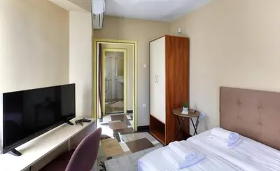 a hotel room with a bed and a large television at HOTEL THE WHITE HOUSE Plovdiv in Plovdiv