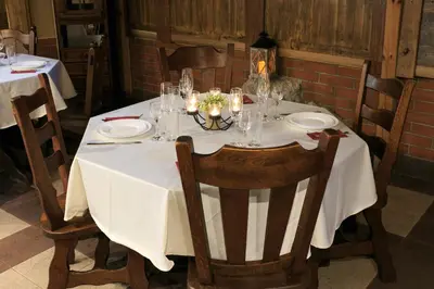 a table with a white table cloth and candles on it at HOTEL THE WHITE HOUSE Plovdiv in Plovdiv