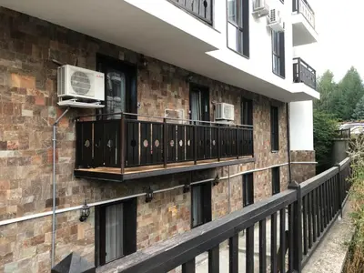 a building with a balcony with two air conditioners at Grand Bansko D104 APARTMENT in Bansko