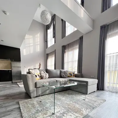 a living room with a couch and a glass coffee table at ATRIUM Boutique Suites Sofia in Sofia