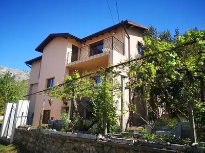 a house with a stone wall in front of it at VillaPo in Ilindentsi