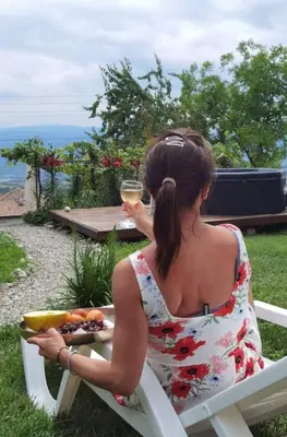 a woman sitting in a chair with a plate of food at VillaPo in Ilindentsi