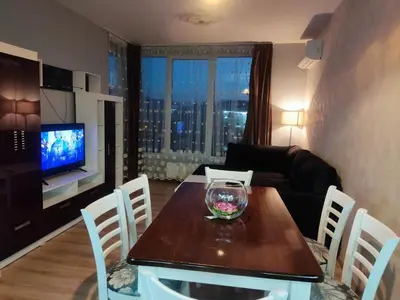 a living room with a dining table and a television at Mountain view apartment in Sofia