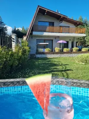 a pool with a rainbow towel in front of a house at Къща за гости Радост Guest House Radost in Razlog
