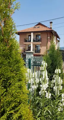 a house with white flowers in front of it at Семеен хотел При Вергил in Sapareva Banya