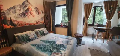 a bedroom with a bed with a painting on the wall at FOX boutique apartment Borovets Gardens in Borovets
