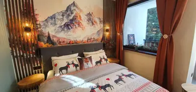a bedroom with a bed with a painting on the wall at FOX boutique apartment Borovets Gardens in Borovets