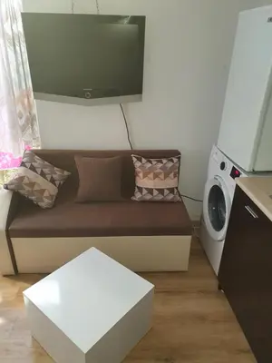 a living room with a couch and a washing machine at THE CENTER Apartments Comfort in Sandanski