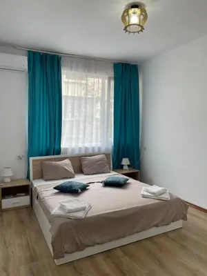 a bedroom with a large bed with blue curtains at THE CENTER Apartments Comfort in Sandanski