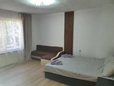 a bedroom with a bed and a couch at Тих двустаен самостоятелен апартамент с двор,до площада на Сандански in Sandanski