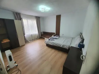 a bedroom with a bed and a wooden floor at Тих двустаен самостоятелен апартамент с двор,до площада на Сандански in Sandanski