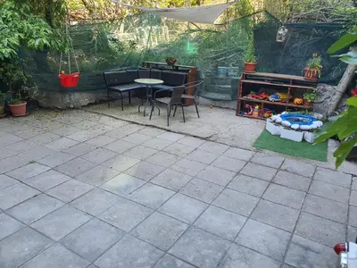a patio with a table and chairs in a backyard at Тих двустаен самостоятелен апартамент с двор,до площада на Сандански in Sandanski