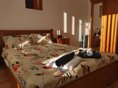 a bed with a comforter with hats and towels on it at Sunny home by the lift in Bansko in Bansko