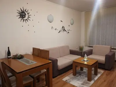 a living room with a couch and a table at Sunny home by the lift in Bansko in Bansko