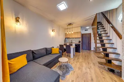 a living room with a couch and a kitchen at Skyday Penthouse Deluxe at Oak Residence in Smolyan
