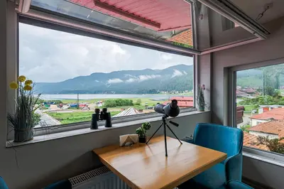 a window in a room with a wooden table and blue chairs at Ardo Spa Hotel and Restaurant in Sarnitsa