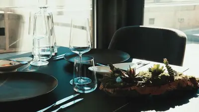 a table with glasses and a plant on top of it at VIZUALIZA Residence Hotel by HMG in Plovdiv