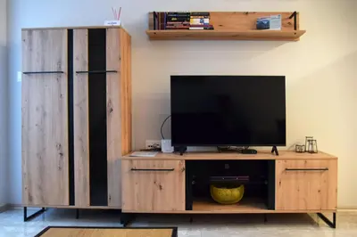 a wooden entertainment center with a flat screen tv at Pirotska 47 apartment in Sofia