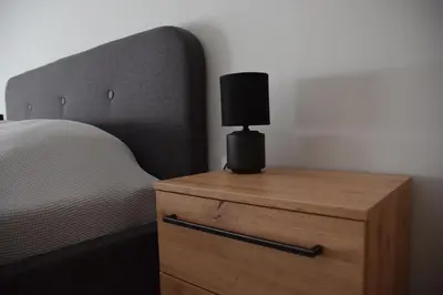 a bedroom with a bed and a nightstand with a lamp at Pirotska 47 apartment in Sofia