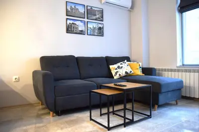 a living room with a blue couch and a table at Pirotska 47 apartment in Sofia