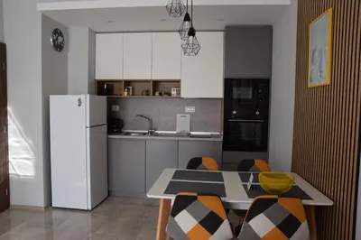 a kitchen with a table and a white refrigerator at Pirotska 47 apartment in Sofia