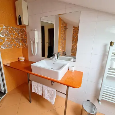 a bathroom with a sink and a mirror at Family Hotel Chiflik Hills in Chiflik