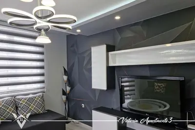 a living room with a tv and a ceiling fan at Victoria apartments 3 in Velingrad