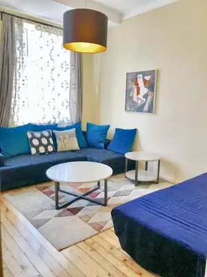 a living room with a blue couch and a table at Charming Apartment Sofia 100m² in Sofia