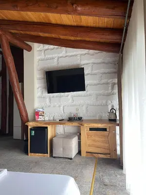 a living room with a tv on a white brick wall at Tihiat Kut Complex in Kyustendil