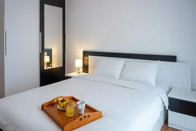 a white bed with a tray of food on it at Sunny 1BDR Apartment near Center in Sofia