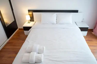 a bedroom with a white bed with towels on it at Sunny 1BDR Apartment near Center in Sofia