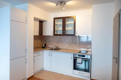a kitchen with white cabinets and a sink at Sunny 1BDR Apartment near Center in Sofia