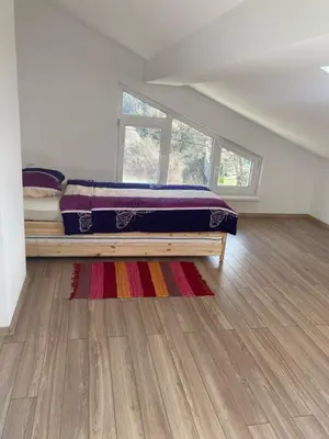 a bedroom with a bed on a wooden floor at Villa Rosa in Krayni Dol