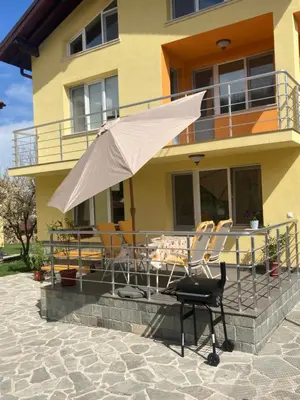 a chair and an umbrella in front of a house at Villa Rosa in Krayni Dol