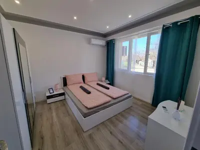 a bedroom with a bed with pink pillows on it at Luxury two bedroom Crown apartament in Botevgrad