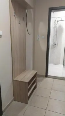 a bathroom with a wooden bench next to a shower at Апартамент Лидия in Chepelare