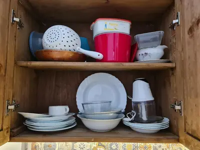 a wooden cabinet filled with plates and dishes at Pirin Golf Apartment HOME with private garden in Bansko