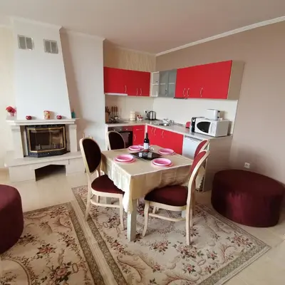 a kitchen with a table and chairs and red cabinets at Grand Monastery Pamporovo Apartment for rent in Pamporovo