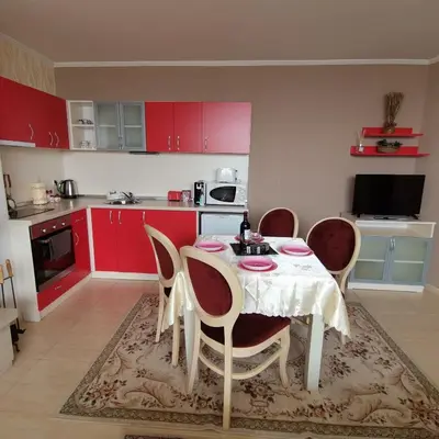 a kitchen with a table and chairs and red cabinets at Grand Monastery Pamporovo Apartment for rent in Pamporovo