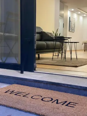 a welcome mat in front of a door with a table at DV13 Luxury Suite Sofia Center in Sofia