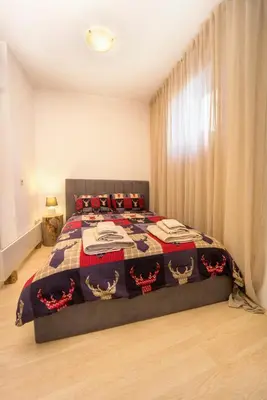 a bedroom with a bed with a quilt on it at Studio 9, St John Park in Bansko