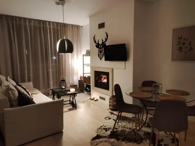 a living room with a couch and a table and a fireplace at Studio 9, St John Park in Bansko