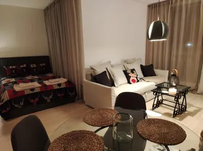 a living room with a couch and tables and a bed at Studio 9, St John Park in Bansko