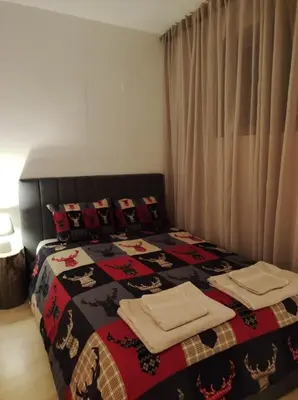 a bedroom with a bed with a blanket and pillows at Studio 9, St John Park in Bansko