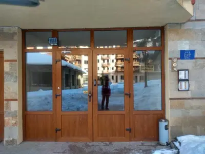a person standing in front of a wooden door at Kolimechkov Apartments Borovets in Borovets