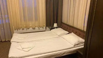 a bedroom with two beds with white sheets and a mirror at GrandView Apartment Grand Monastery in Pamporovo