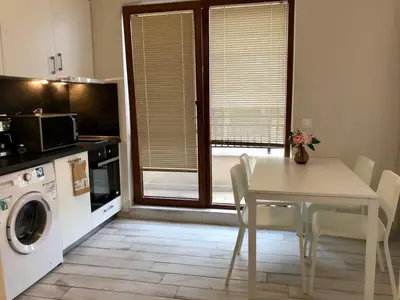 a kitchen with a white table and chairs and a microwave at Sunny Dream Apartments in Sofia